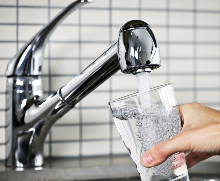 A glass being filled with water containing fluoride